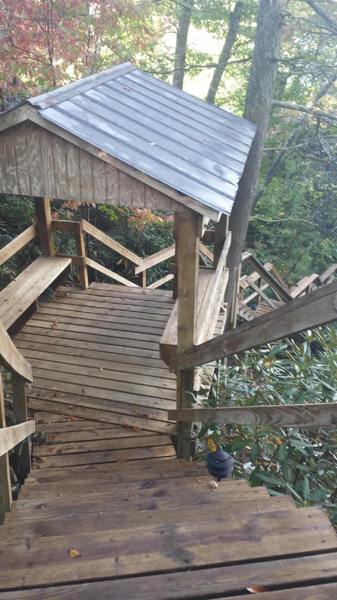 Metal roofed shelter over wooden steps on a wooded walkway — Skylight Repair & Installation work by our crew in Morristown